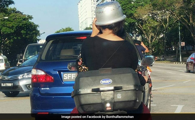 हेलमेट नहीं मिला तो लड़की ने सिर पर पहन लिया कुकर, खूब वायरल हो रही है Photo हेलमेट नहीं मिला तो लड़की ने सिर पर पहन लिया कुकर, खूब वायरल हो रही है Photo