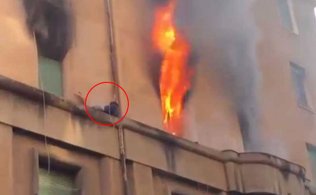 In Dramatic Video, Man Clings To Building Ledge As Flames Rage Inside
