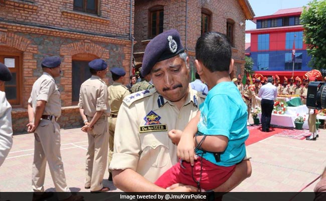 Policeman Carrying Killed Cop's 4-Year-Old Son Breaks Down During Homage