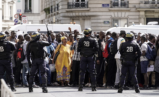 Hundreds Of Migrants Occupy Paris Landmark