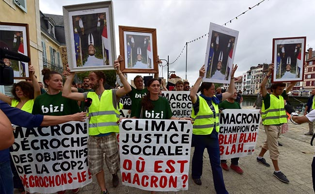Anti-G7 Protesters March With 'Stolen' Portraits Of Emmanuel Macron