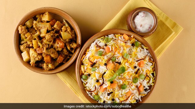 To layer the biryani start with a bed of boiled rice, a teaspoon of ghee, sprinkle of crispy onions