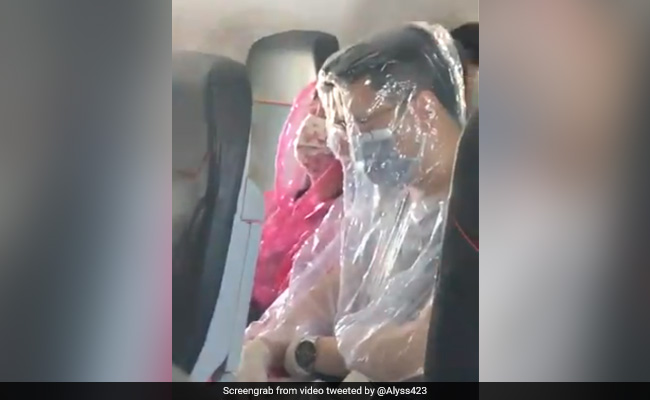 Coronavirus के डर से फ्लाइट में खुद को प्लास्टिक में लपेटे हुए नजर आए यात्री, देखें Viral Video