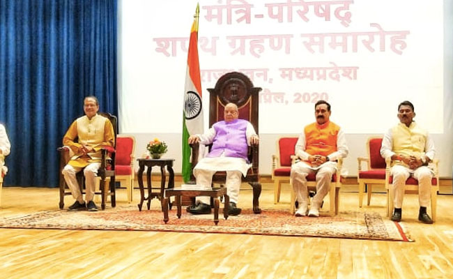 MP: सोशल डिस्टैंसिंग का पालन हुआ, लेकिन Mask के बिना स्टेज पर दिखे राज्यपाल, मुख्यमंत्री और शपथ लेने पहुंचे मंत्री