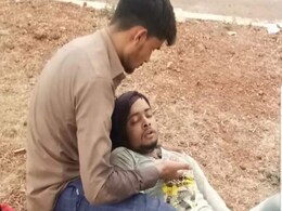 Migrant Lies On Friend's Lap On Road. Story Behind Moving Picture Migrant Lies On Friend's Lap On Road. Story Behind Moving Picture