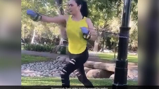 Preity Zinta does stretching exercise with resistance bands in a park