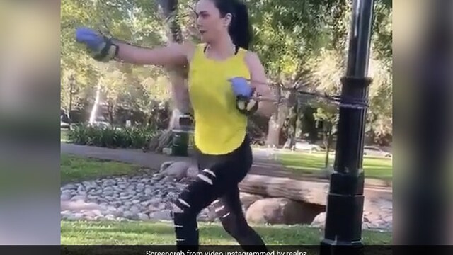 Preity Zinta does stretching exercise with resistance bands in a park
