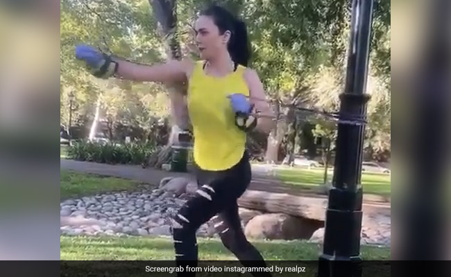 Preity Zinta does stretching exercise with resistance bands in a park