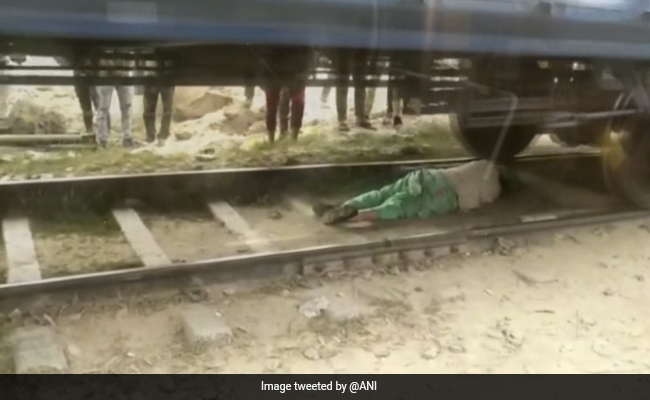 रोहतक में चलती ट्रेन से बचने के लिए पटरियों के बीच लेट गई महिला- देखें VIDEO