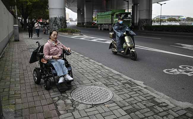 Wheelchair Users In China Dodge Traffic On Rough Road To Recognition