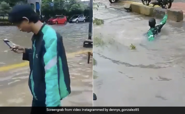 सड़क पर भरे पानी के बीच मोबाइल देखते हुए जा रहा था शख्स, अचानक गहरे नाले में गिरा और फिर... - देखें Video