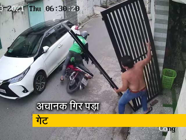 स्कूटर से जा रहे शख्स पर गिरा दरवाजा, VIDEO में देखिए कैसे बचा