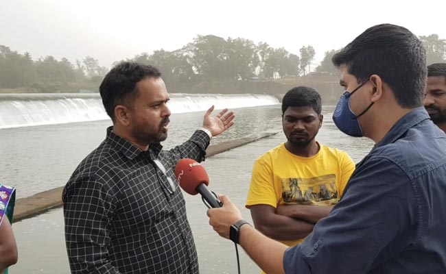 पानी के बहाव से पुल का हिस्सा टूटने के बाद बिजली के खंबे से नदी पार करने को मजबूर हैं यहां लोग