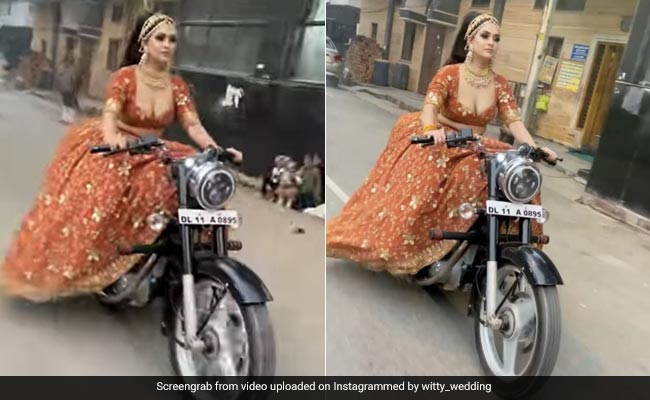 दुल्हन ने स्वैग के साथ की एंट्री, शादी के जोड़े में खुद सड़क पर लेकर निकली बुलेट - देखें Video