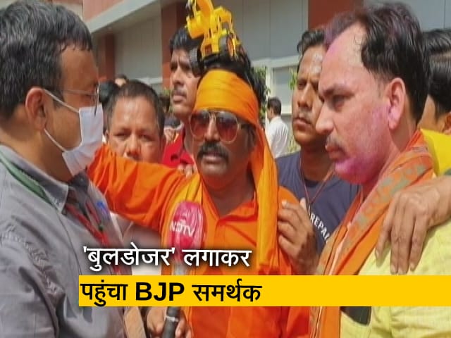सिर पर 'बुलडोजर' लगाकर पहुंचा BJP समर्थक, कहा- यूपी में 11 मार्च से फिर चलेगा बुलडोजर 