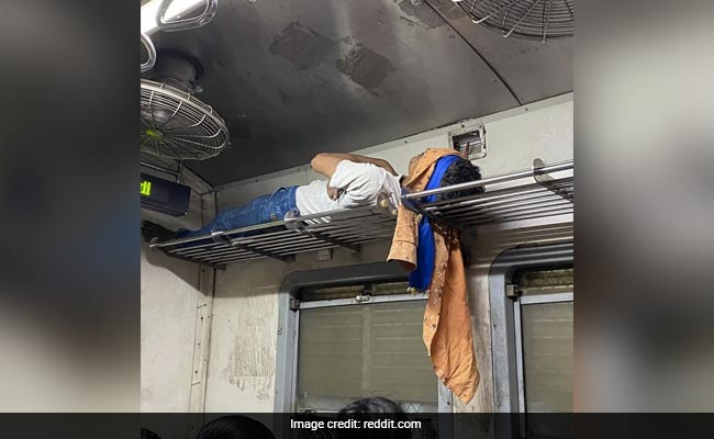 Photo of Man Sleeping On Luggage Rack Of Mumbai Local Blows Internet Away