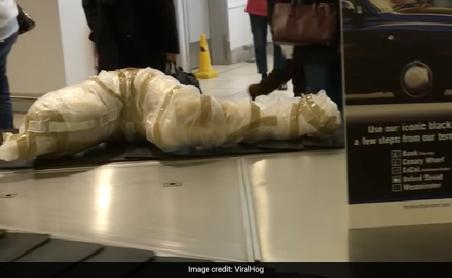 Confused Passengers Look On As "Corpse Like" Package Appears At Airport