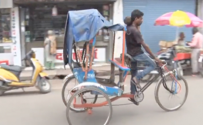 एक हाथ में बच्चा, दूसरे में साइकिल रिक्शे का हैंडल, बेबस पिता की कहानी...