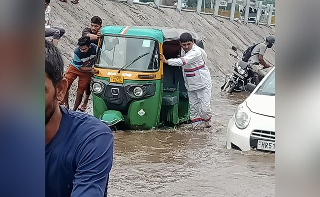 पुलिस - आपके लिए, आपके साथ : भारी बरसात में पानी में फंसे वाहनों को धक्का देकर निकाल रहे पुलिसकर्मी