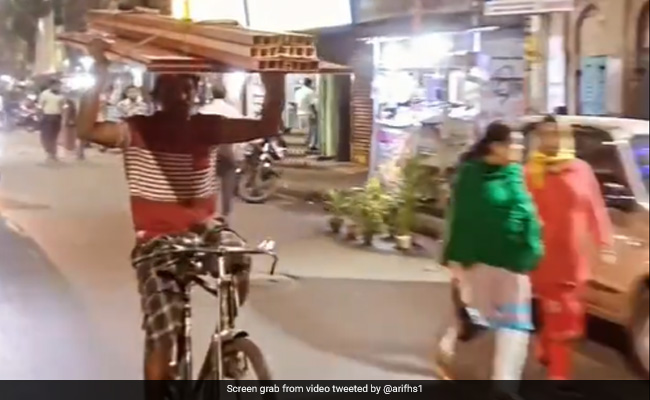Viral Video Shows A Man Riding Bicycle While Holding Planks On His Head