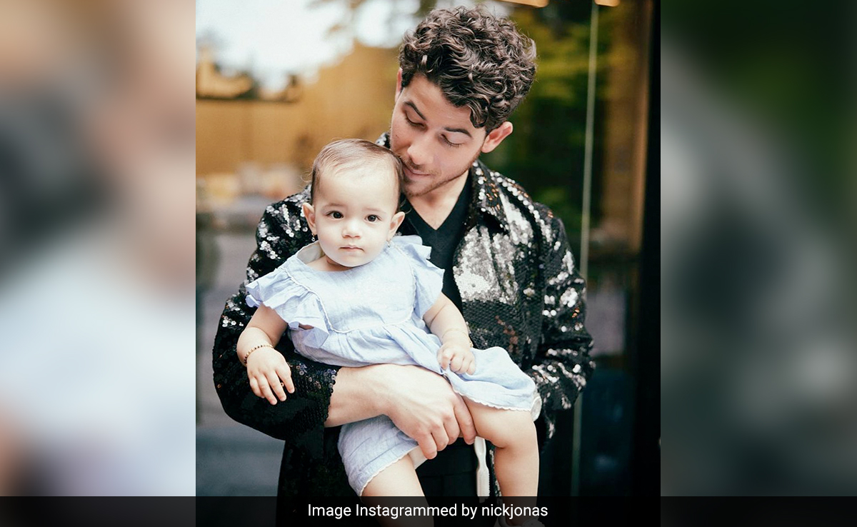 With Nick Jonas In A Sequin Shirt, Malti Marie Jonas Aces A Summery Ruffled Dress In Her Dad's Arms