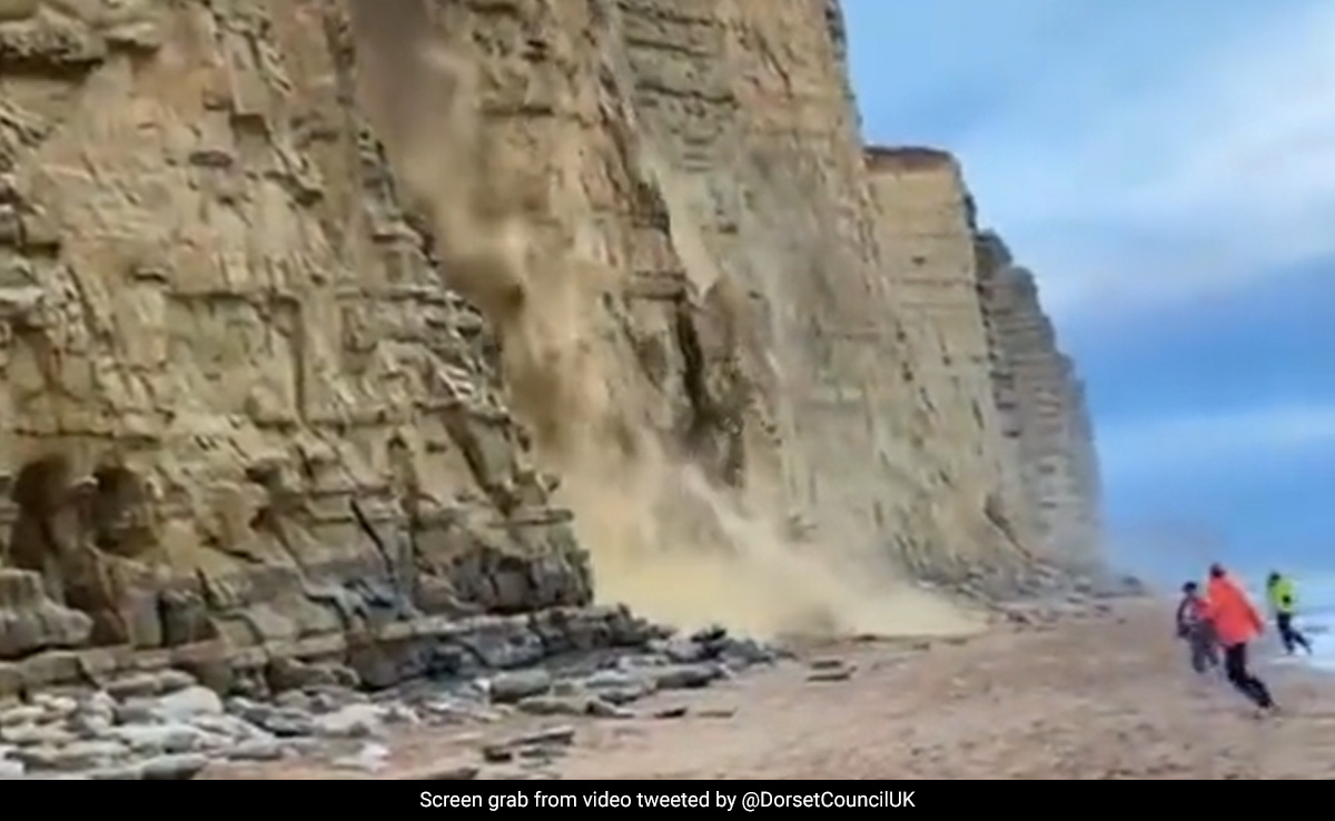 Caught On Camera: Tourists Narrowly Escape As Crumbling Cliff Smashes Into UK Beach