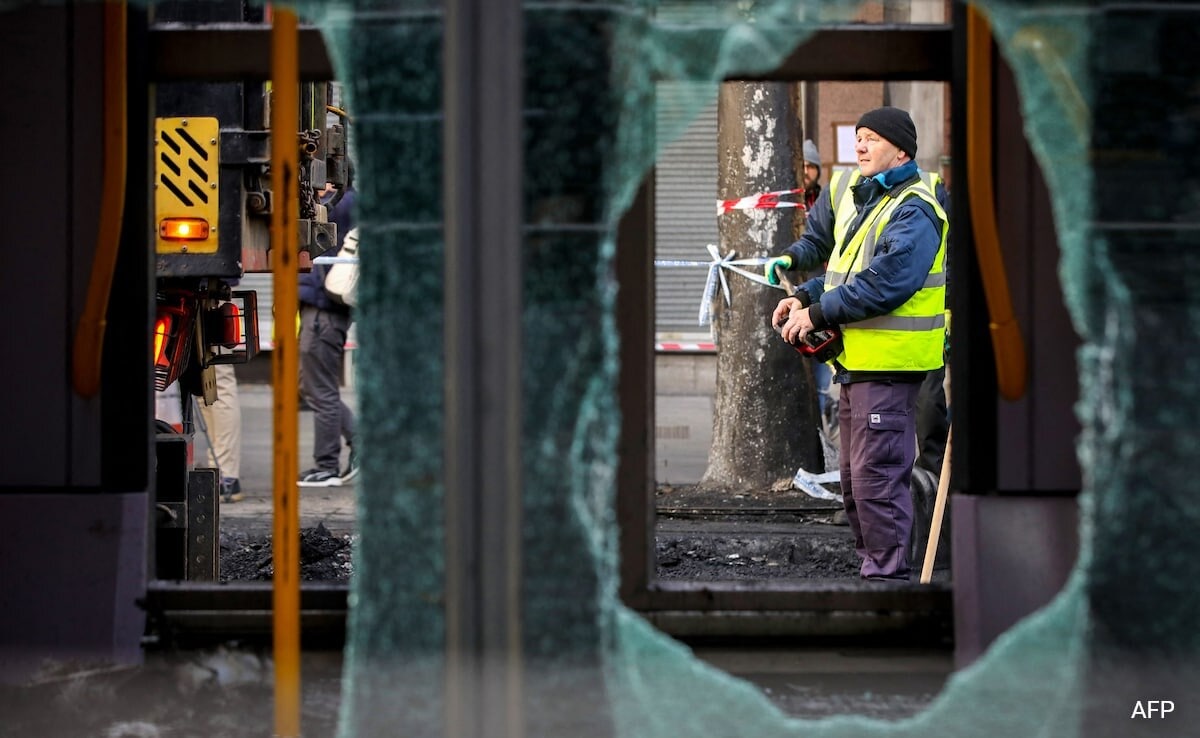 Workers attend the scene of a fire-damaged Luas tram on OConnell Street in Dublin on November 24, 2023, following a night of protests. Workers attend the scene of a fire-damaged Luas tram on OConnell Street in Dublin on November 24, 2023, following a night of protests.