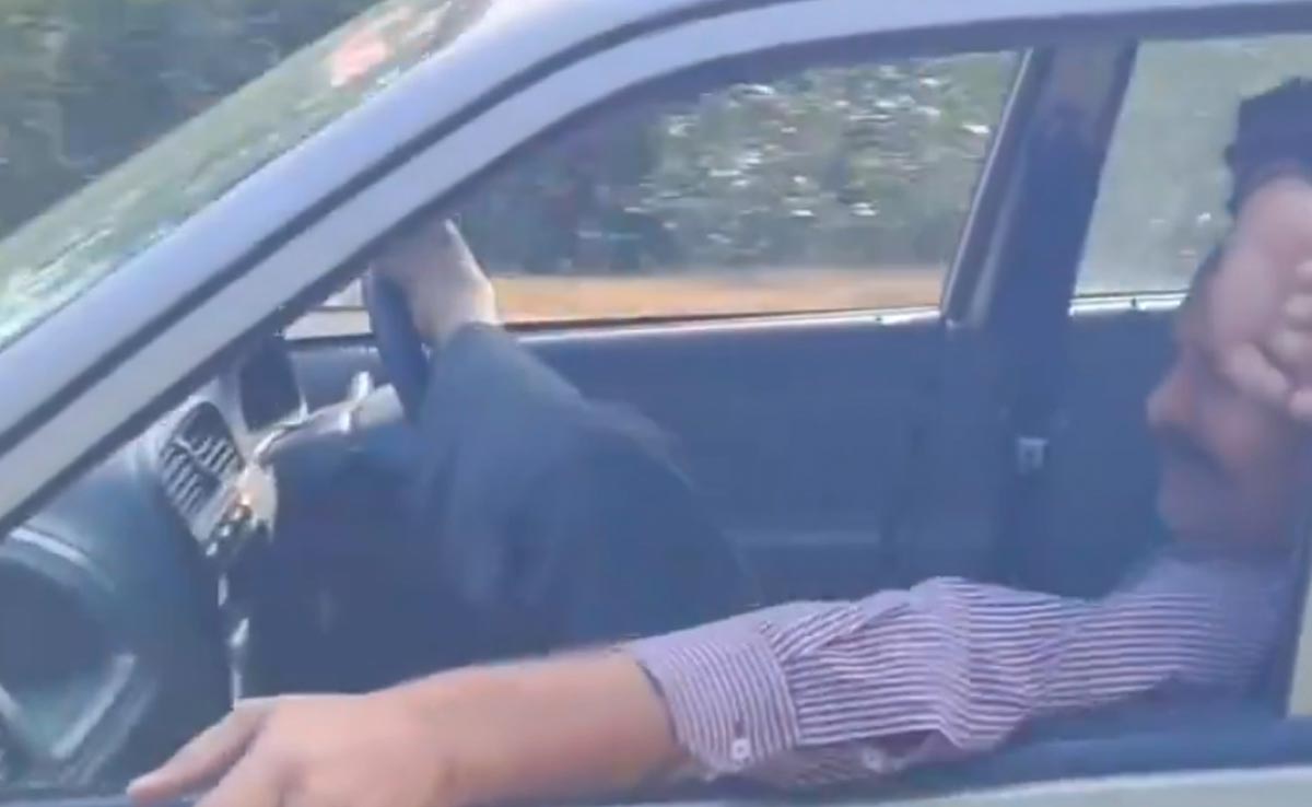 चलती कार के अंदर फैलकर पैरों से घुमाया स्टीयरिंग, लोगों ने कहा- इसीलिए टेस्ला इंडिया नहीं आ रहा