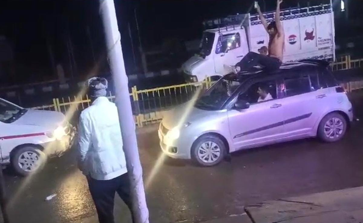 पुलिस के सामने चलती कार पर खड़े हो कर डांस करता रहा युवक, चुपचाप देखते रहे जवान