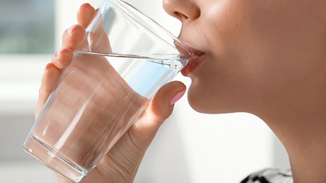 Drinking water helps regulate body temperature by enabling sweating, which cools the body