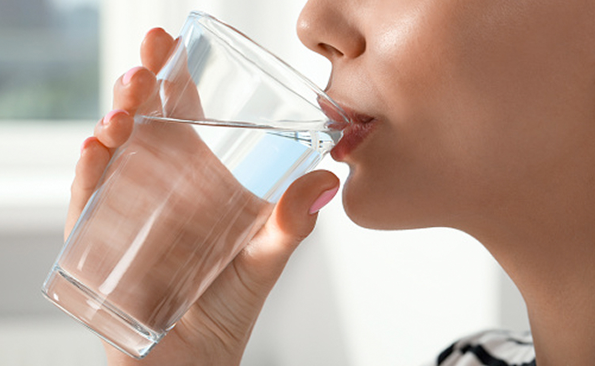 Drinking water helps regulate body temperature by enabling sweating, which cools the body