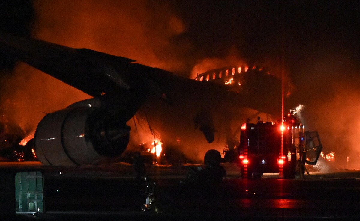 Firefighters trying to extinguish a fire on a Japan Airlines plane