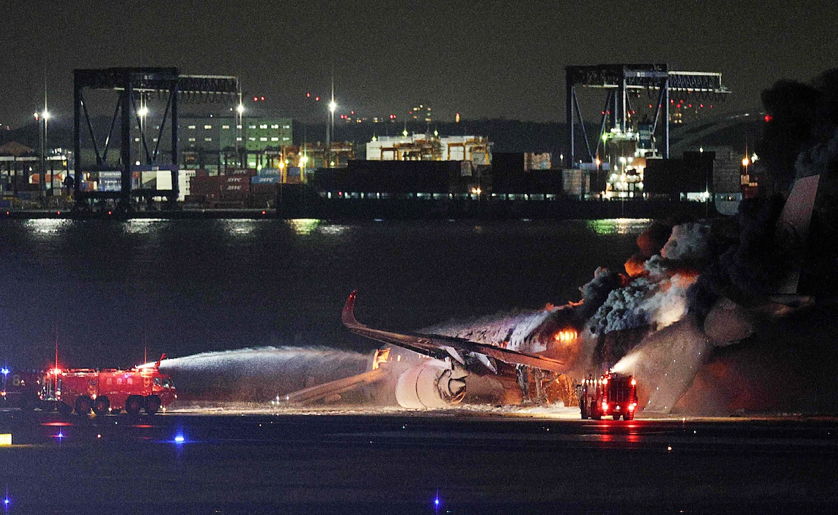 Firefighters attempting to douse a fire on the Japan Airlines plane