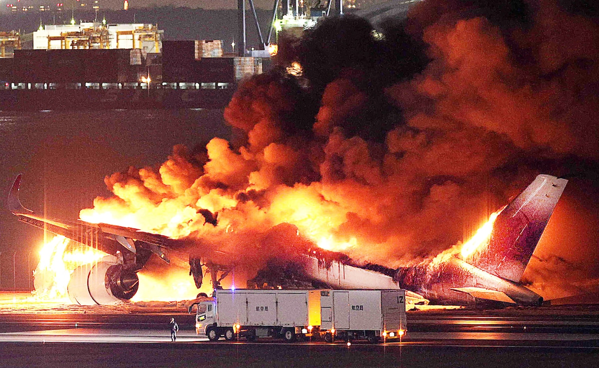 Firefighters work at Tokyos Haneda International Airport after Japan Airlines A350 airplane caught fire