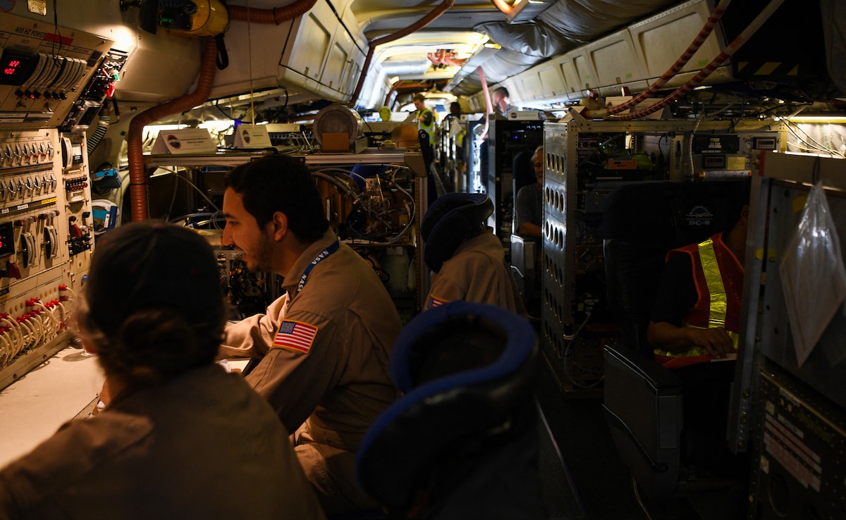 Crew and scientists of NASAs DC-8 airborne science laboratory work inside the aircraft