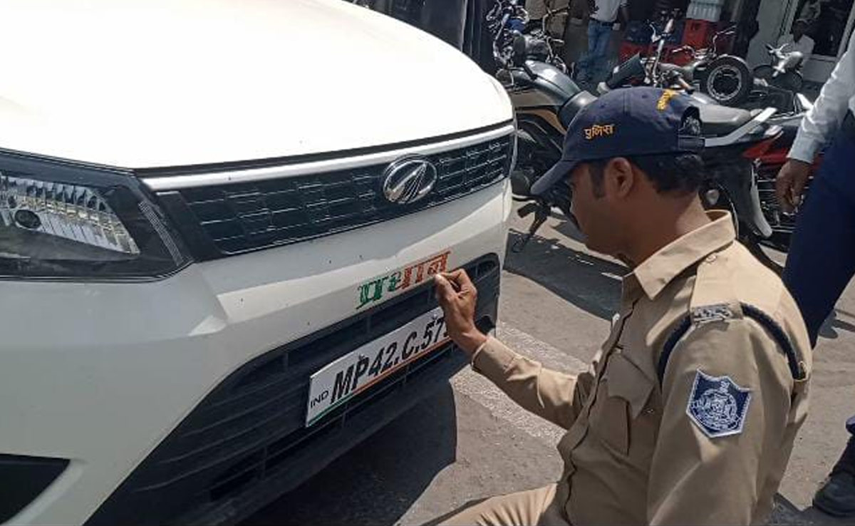 Dewas में खुलेआम उड़ रही आचार संहिता की धज्जियां, पुलिस खुद मिटाती दिखी गाड़ियों में छपे चिन्ह