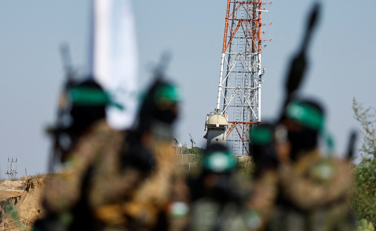 Palestinian fighters from the armed wing of Hamas take part in a military parade in front of an Israeli military site to mark the anniversary of the 2014 war with Israel, near the border in the central Gaza Strip, July 19, 2023.
