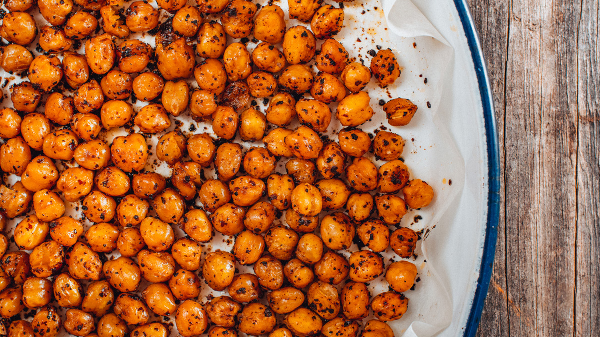 Spread the seasoned chickpeas on a baking tray lined with parchment paper to cook it