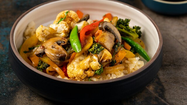 For the vegetables, she heats a little oil and adds garlic, onions, mushrooms, etc.