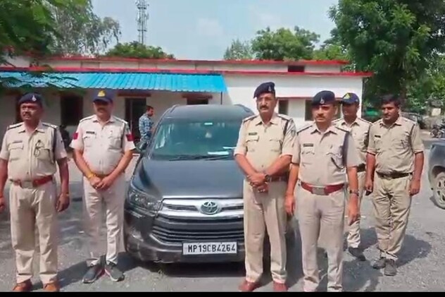 थाने में जब्त की गई इनोवा कार के साथ पुलिस के अधिकारी और सिपाही,चित्र में आप देख सकते हैं बीजेपी का झंडा नहीं दिख रहा.