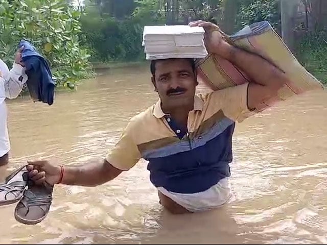 Slippers In Hand And Notebook On Head, Teachers Walk In Waist-Deep Floodwater In Darbhanga