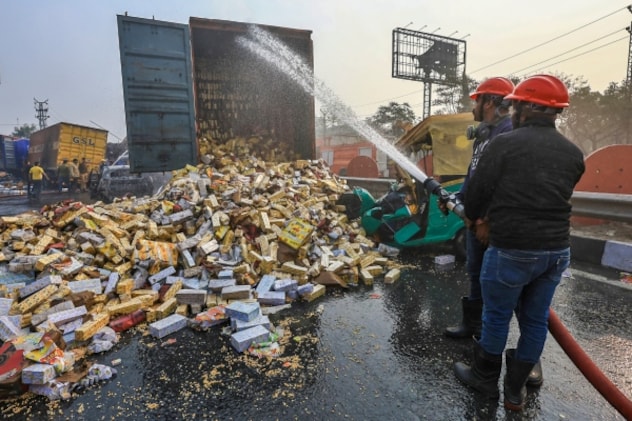 माचिस से भरे ट्रक पर पानी डालकर आग बुझाते हुए फायर ब्रिगेडकर्मी. माचिस से भरे ट्रक पर पानी डालकर आग बुझाते हुए फायर ब्रिगेडकर्मी.