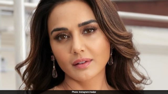 Preity Zinta begins her workout by executing dumbbell squats, which enhance core stability