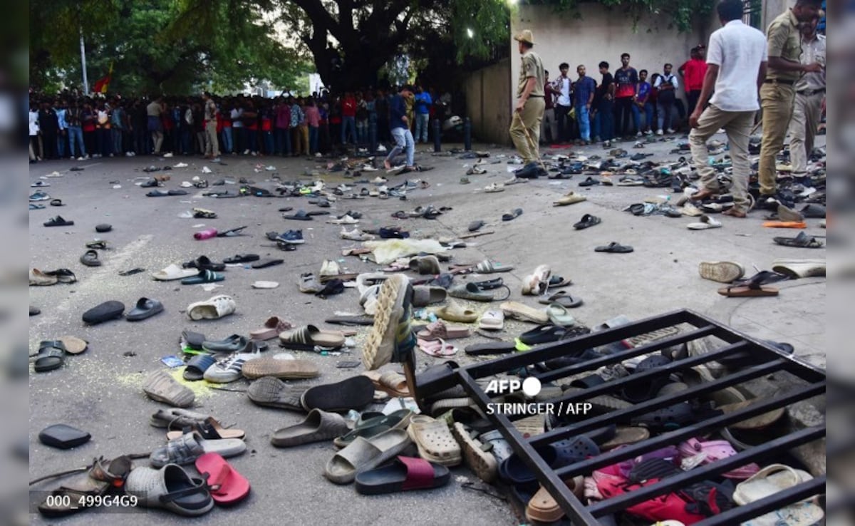 Fans stand next to abandonned shoes and a fallen barrier following a stampede during celebrations. Fans stand next to abandonned shoes and a fallen barrier following a stampede during celebrations.