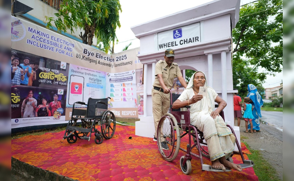 A volunteer assists an elderly voter at a polling booth in West Bengal. 