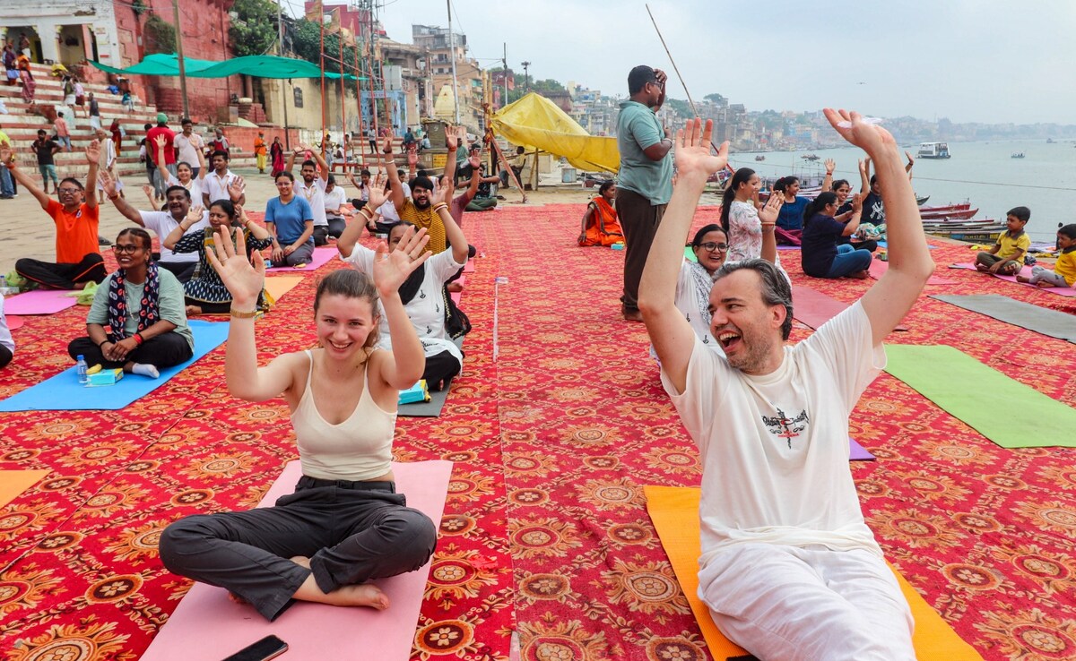 Foreign tourists at a yoga session on the banks of River Ganga in Varanasi, Uttar Pradesh