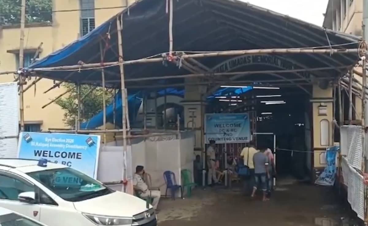 Amid continuous rainfall, voters line up outside a polling station in the Kaliganj area in West Bengal. 