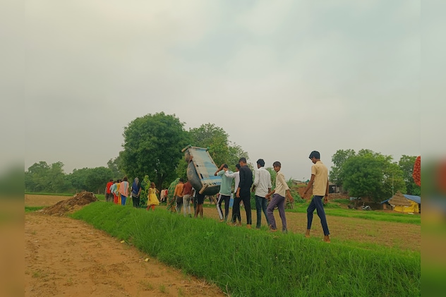 ग्रामीण बच्चों को नदी से पार कराते हैं. ग्रामीण बच्चों को नदी से पार कराते हैं.