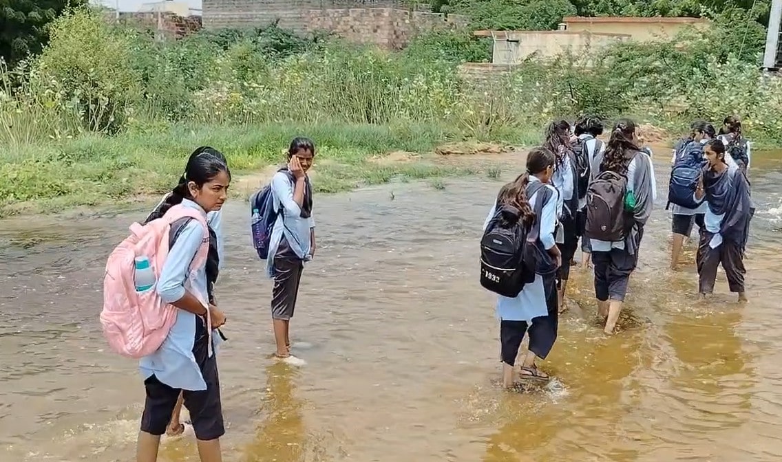 बच्चों को ज़हरीले पानी से होते हुए स्कूल जाना पड़ता है बच्चों को ज़हरीले पानी से होते हुए स्कूल जाना पड़ता है