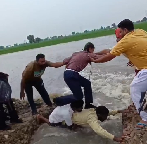 2 Men Form Human Bridge, Help 35 Children Cross Flooded Field In Punjab